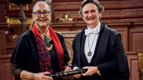 Fisher Studios June Northcroft Grant one of Mākereti Papakura's relatives receiving the posthumous degree from Professor Irene Tracey, Vice Chancellor of the University of Oxford in the Sheldonian Theatre, Oxford.