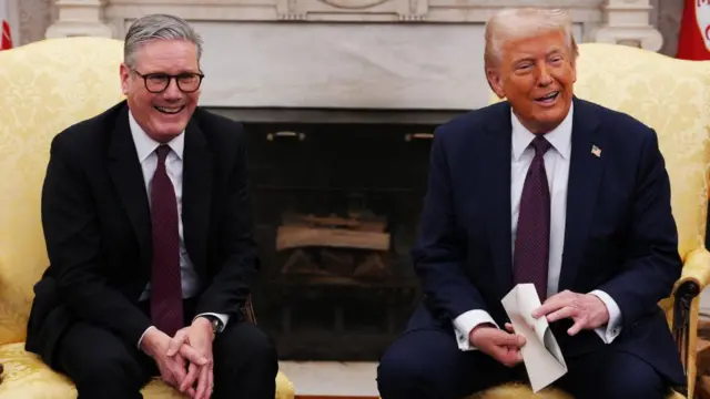 Starmer and Trump laugh, seated next to each other on the Oval Office's high-backed chairs
