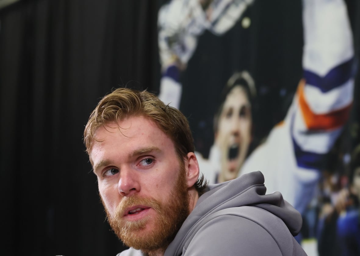 A men's hockey player looks on during a press conference.