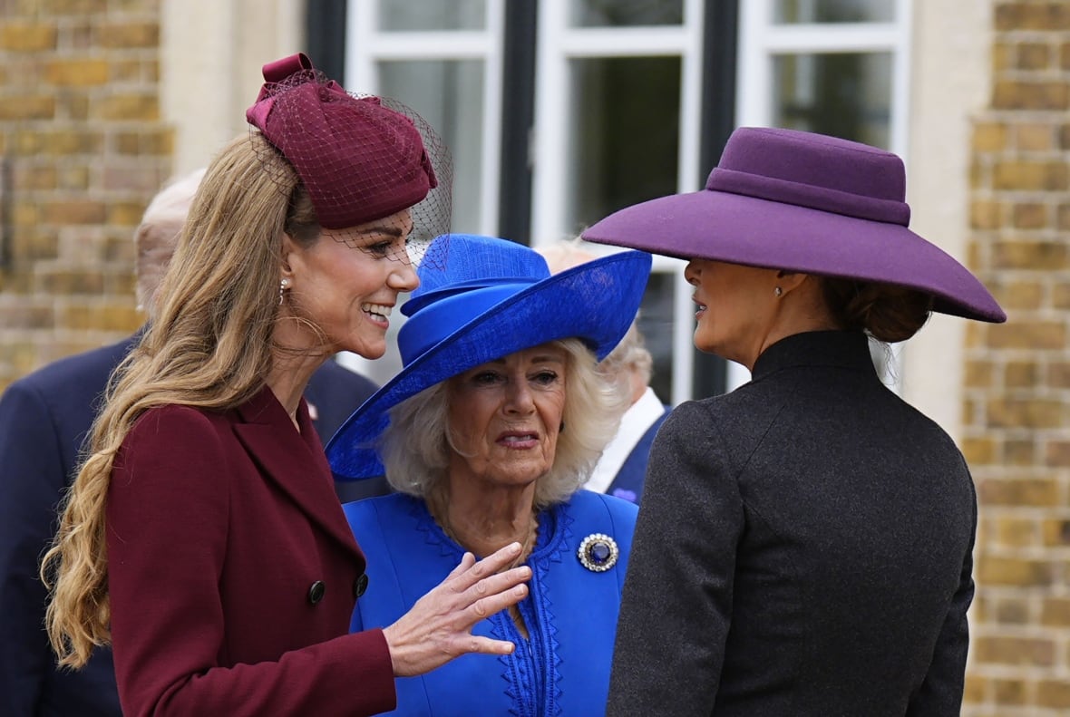 Three women in formal dress and hats  smile and talk together