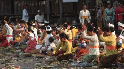 Getty Images Balinese women praying during a religious ceremony.