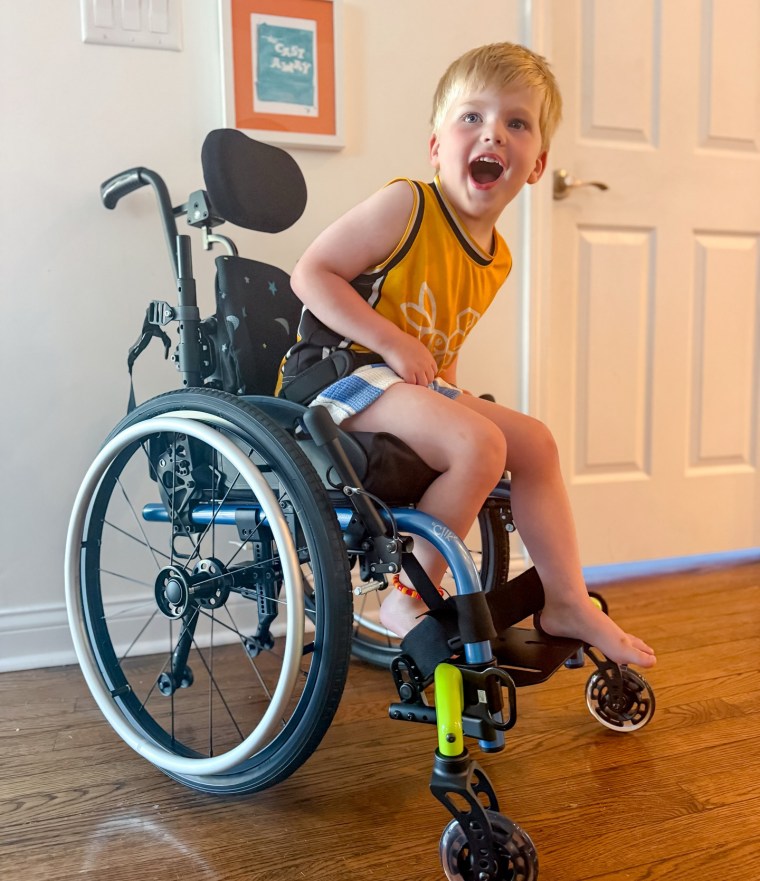 Beckett Wear sits in a wheelchair inside of a room
