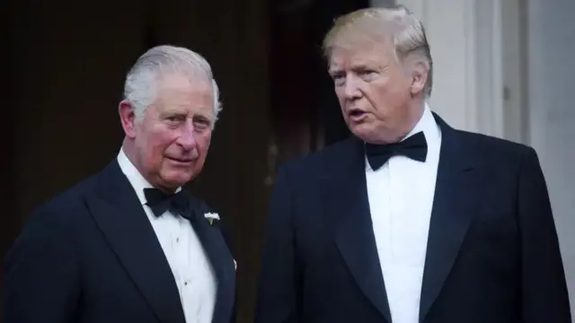 King Charles III stands next to US President Donald Trump. Both are in tuxedos