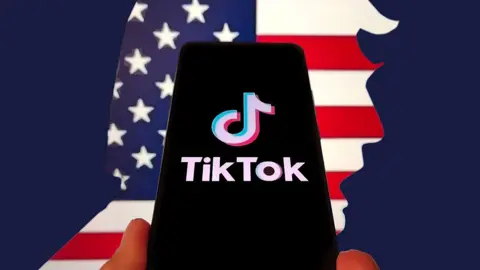 Getty Images In this photo illustration, the logo of TikTok is displayed on a smartphone screen on April 5, 2025 in Shanghai, China. In the background is the American flag, cut  in the shape of Donald Trump's face. 