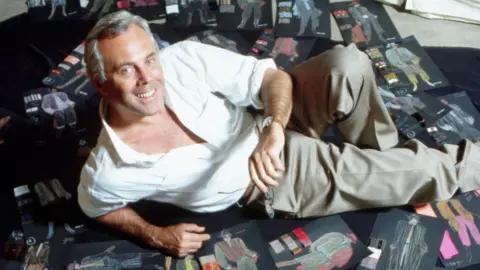 Getty Images Giorgio Armani lying on dozens of black sheets showing clothes sketches on the floor, in 1982