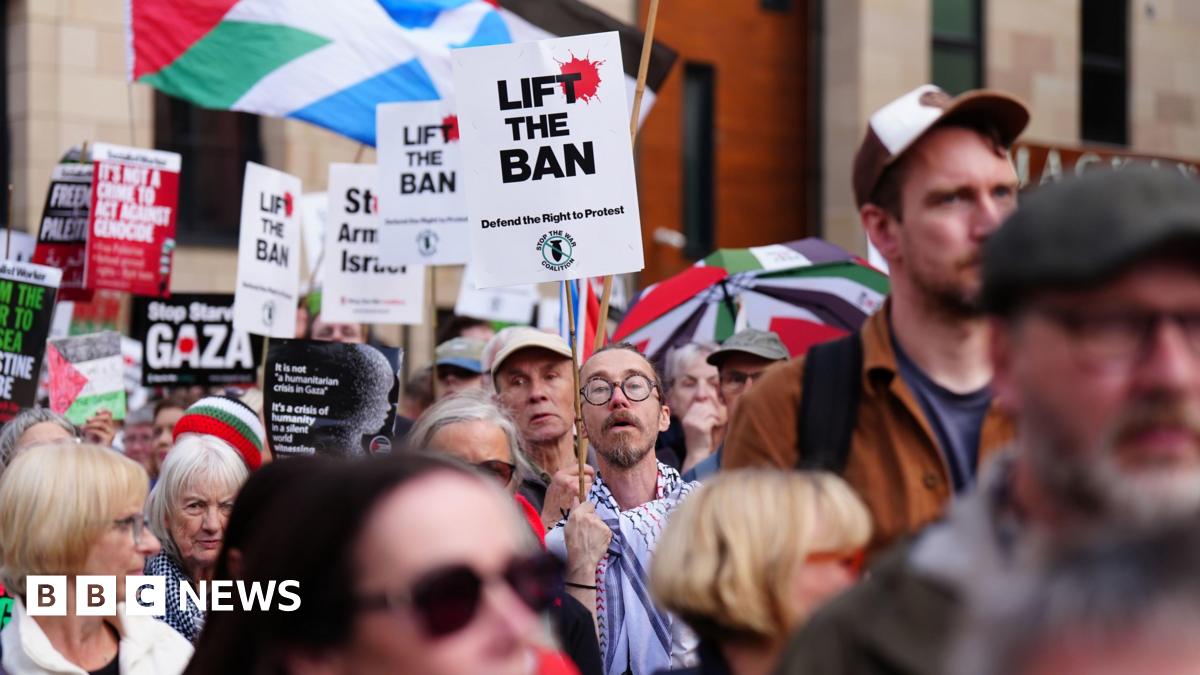 Pro-Palestine protesters in Edinburgh with signs held up in the air saying "Lift the Ban"