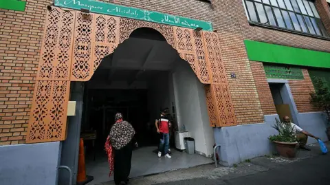 Getty Images Faithfuls leave and arrive at the Mosque Islah, in Montreuil, Seine-Saint-Denis, on the outskirts of Paris, where pigs' heads were earlier discovered at the entrance of the building. 