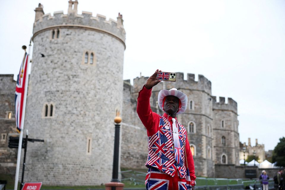 A man in a Union Jack suit takes a selfie outside Windsor Castle ahead of U.S. President Donald Trump and First Lady Melania Trump's arrival, in Windsor, Britain, September 17, 2025. REUTERS/Phil Noble