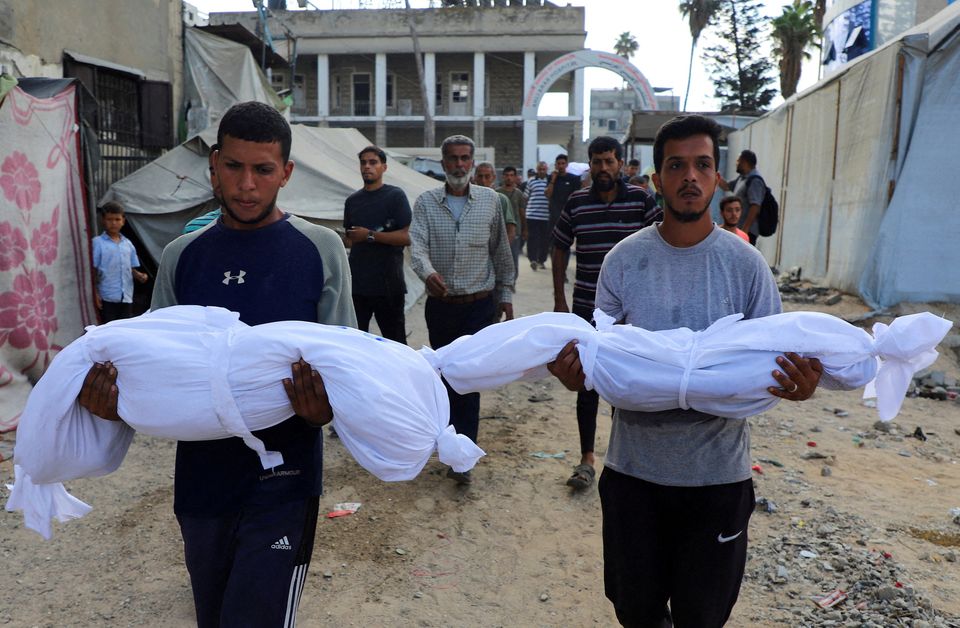 Mourners carry the bodies of Palestinian children, who, according to medics, were killed in a deadly overnight Israeli strike on a building where displaced people were taking shelter, amid an Israeli military operation, at Al-Ahli Arab Hospital in Gaza City, September 24, 2025. REUTERS/Ebrahim Hajjaj    