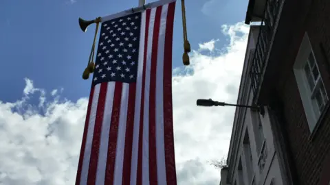 BBC The Stars and Stripes flag hanging vertically from a flag pole outside a building just a hundred yards or so from Windsor Castle.  