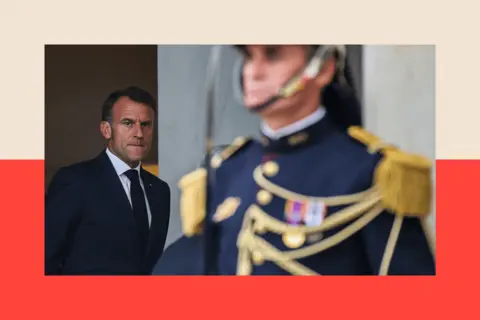 LUDOVIC MARIN/AFP via Getty Images Emmanuel Macron in the background 