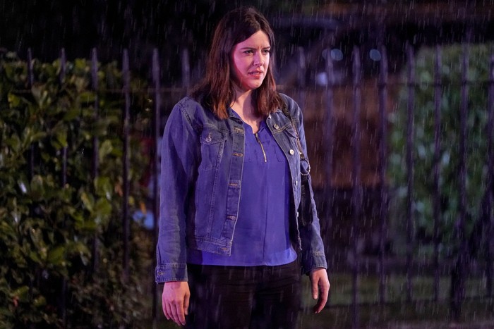 Michelle Ryan as Zoe Slater standing in Albert Square gardens at night in EastEnders.