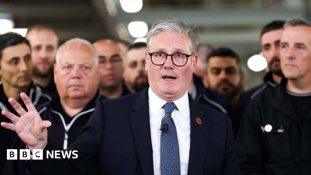 UK Prime Minister Keir Starmer (centre) speaks to the media after a phone conversation with US President Donald Trump, at a Jaguar Land Rover automobile manufacturing plant in the West Midlands back in May. JLR workers are crowded behind him.