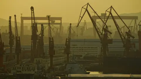 A dockyard in China is photographed in a hazy, yellow light. 