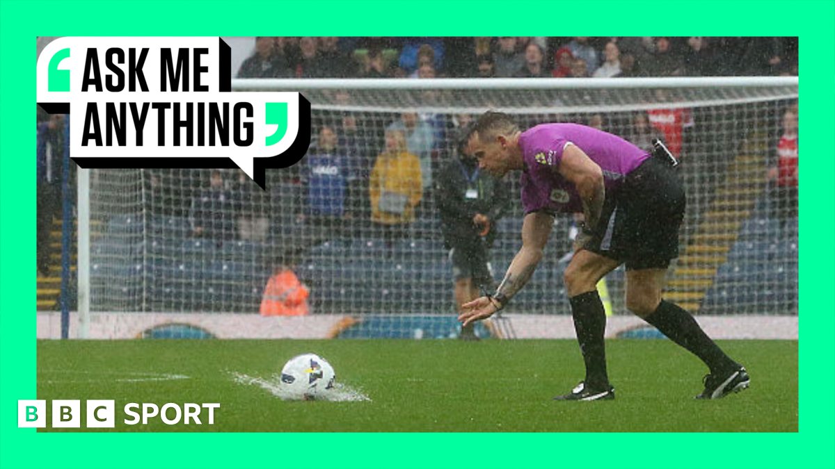 A referee rolls a ball that splashes on the pitch at Blackburn Rovers