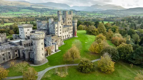 Paul Harris | National Trust Drone view of the white stone Penrhyn Castle set against the green Welsh countryside 