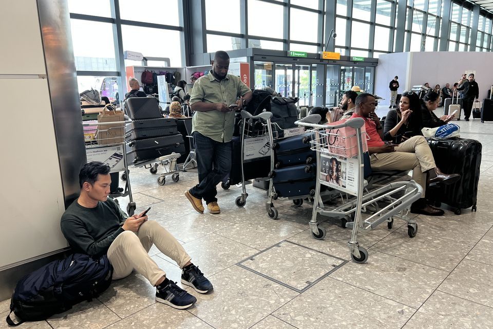 People at London's Heathrow Airport after flights were delayed and cancelled after a cyber attack targeted a service provider for check-in and boarding systems. Photo: PA.