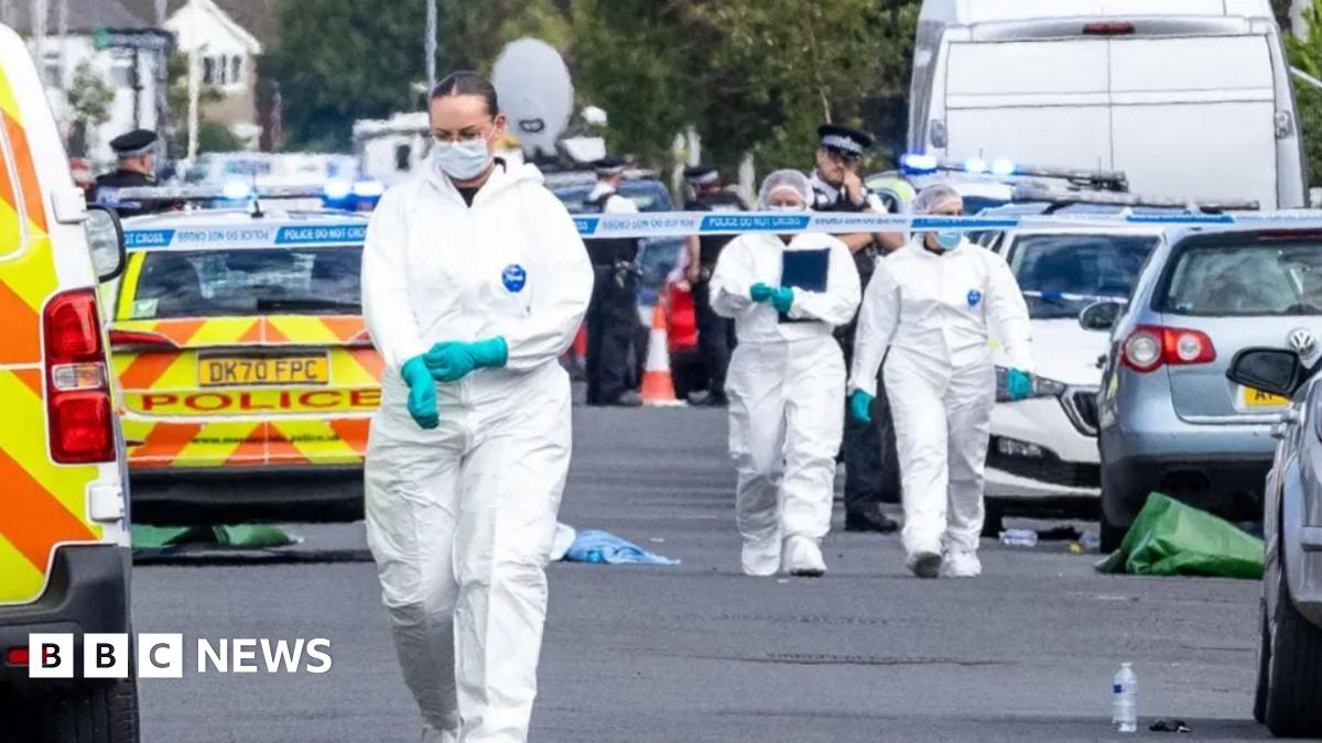 A resident walks with a shovel along a mud-covered road in Hualien on September 24, 2025, following the bursting of a barrier lake during the passing of Super Typhoon Ragasa.