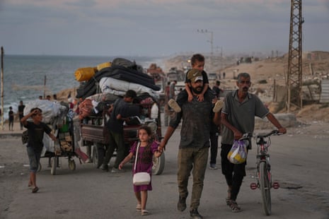 Displaced Palestinians flee northern Gaza along the coastal road toward the south, as Israel announced an expanded operation in Gaza City.