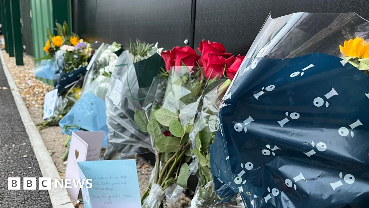 A number of floral and card tributes left for the late Billy Vigar at Chichester City football club. Six separate floral tributes can be seen in a row alongside three cards.