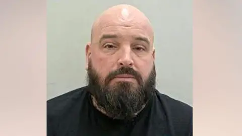 Lancashire Police A police mugshot of Neil Platt, who has a bald head and a thick black beard.