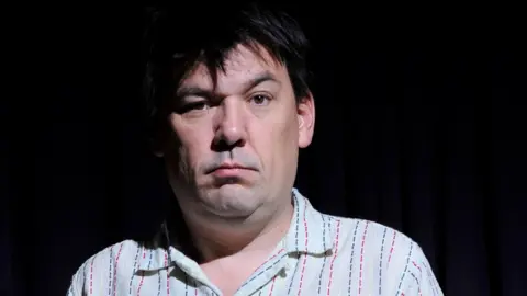 Getty Images Graham Linehan in a white shirt, lookiing serious 