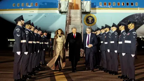 Reuters President Trump and Melania Trump's welcoming line-up on the runway at Stansted airport. 
