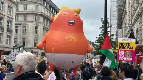 Trump Baby blimp carried above the crowd