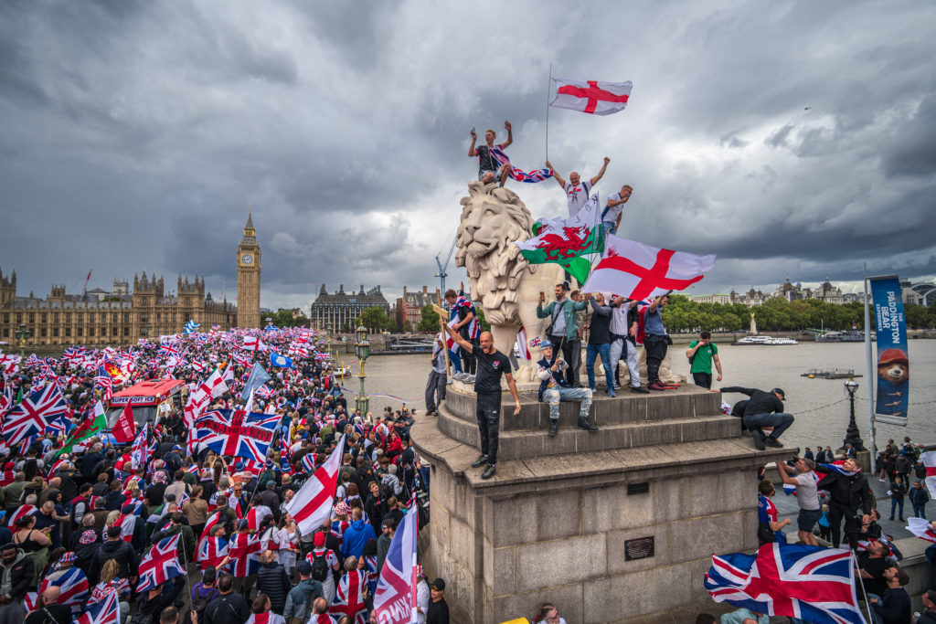 Protesters wave Union Jack and St George's England flags during the "Unite The Kingdom" rally on Westminster Bridge by the...