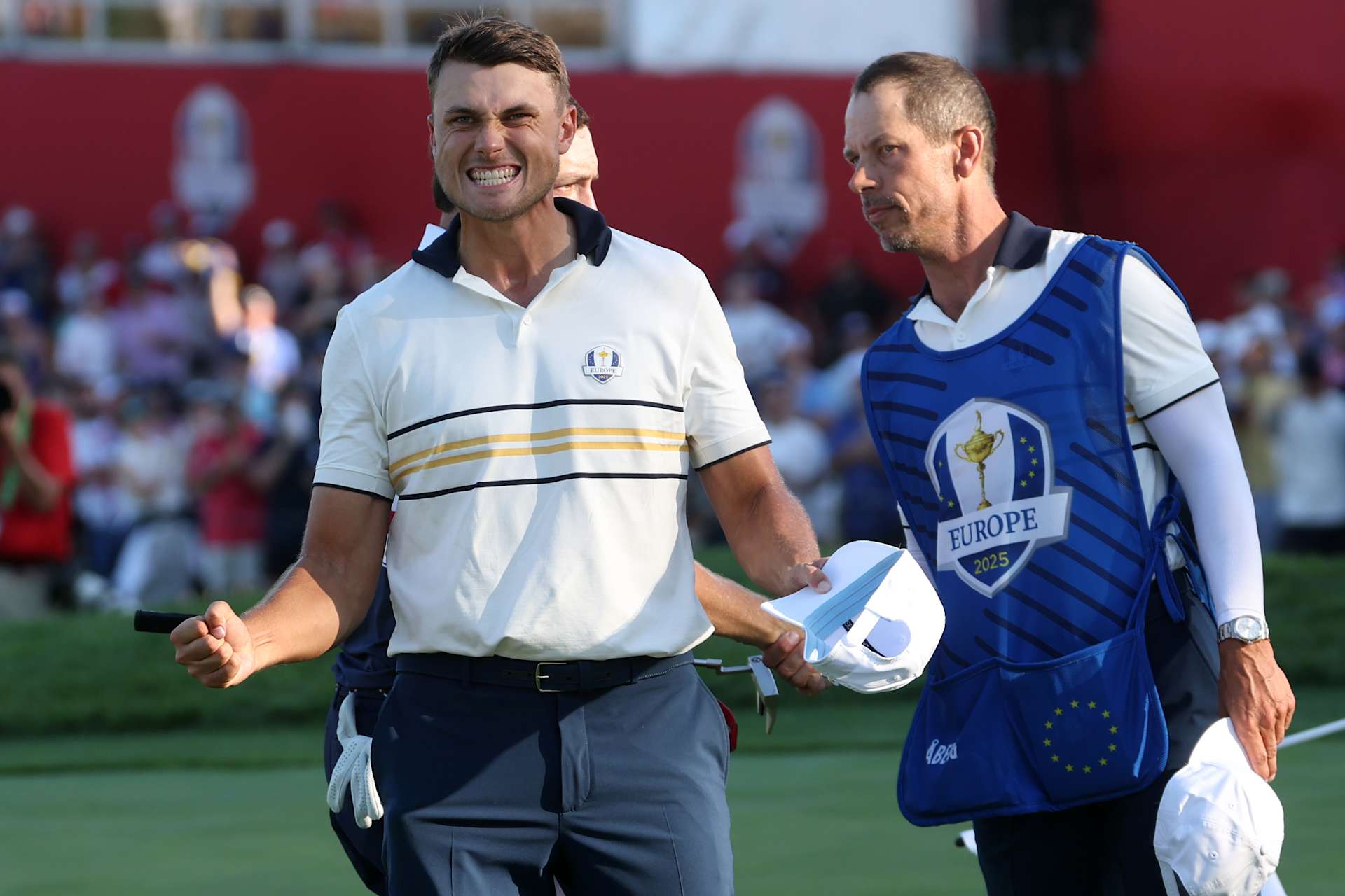 FARMINGDALE, NEW YORK - SEPTEMBER 28: Ludvig Aberg of Team Europe and caddie Joe Skovron react after defeating Patrick Cantlay of Team United States (not pictured) on the 18th green during the Sunday singles matches of the 2025 Ryder Cup at Black Course at Bethpage State Park Golf Course on September 28, 2025 in Farmingdale, New York. (Photo by Jamie Squire/Getty Images)