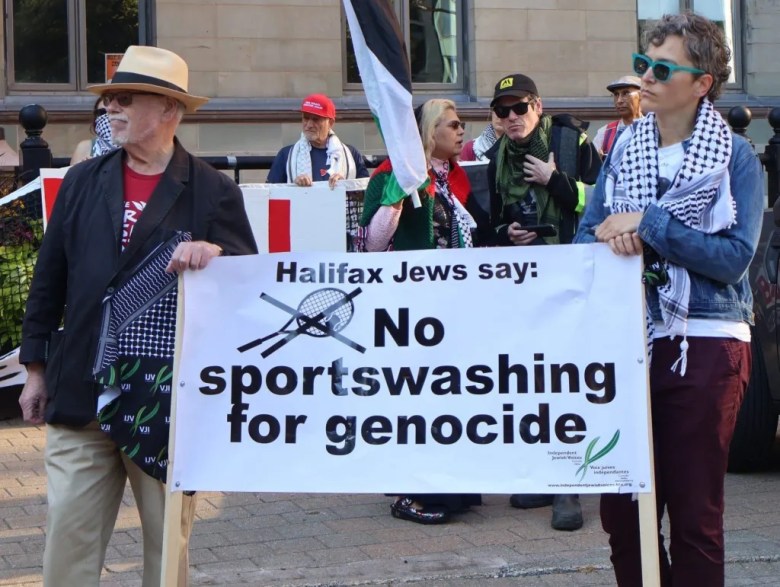 A senior white man and a white woman are holding a banner that reads "Halifax Jews say: No sportswashing for genocide."