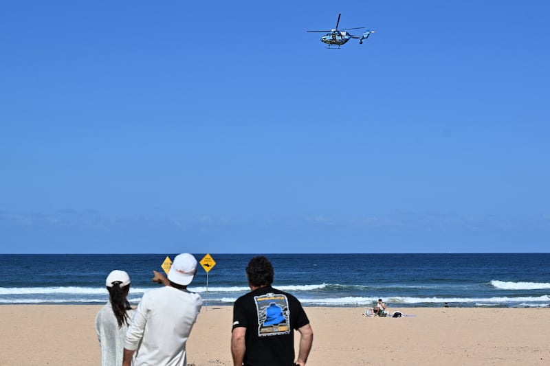 A helicopter scans the water following a shark attack at Long Reef beach on Saturday. Photograph: Saeed Khan/AFP via Getty Images         