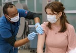 Ermias Asfaw, RN, left, gives Loren Campos, 16, an immunization at a vaccination clinic held at McDaniel High School in Northeast Portland, Feb. 8, 2023. 