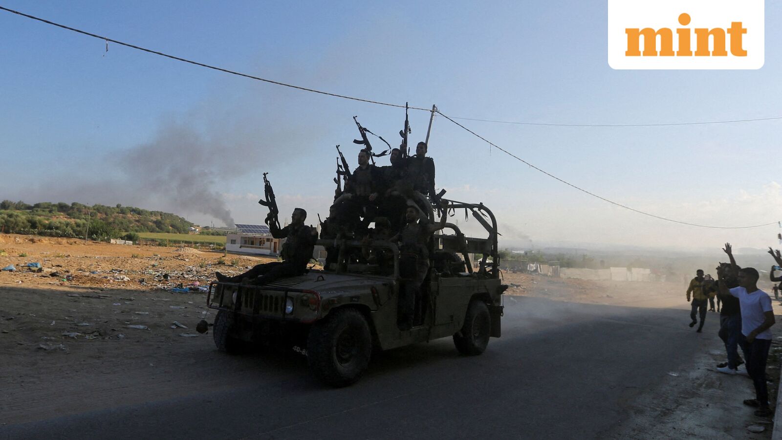 Palestinian militants ride an Israeli military vehicle that was seized by gunmen who infiltrated areas of southern Israel, in the northern Gaza Strip October 7, 2023.