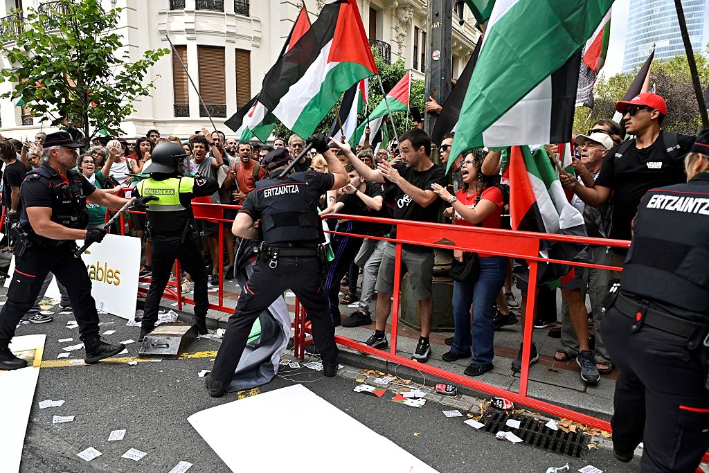 Basque regional police 'Ertzaintza' officers use truncheons againt pro-Palestinian protesters holding Palestinian flags during the eleventh stage of the Vuelta a Espana cycling tour, a 167 km race from Bilbao to Bilbao, on September 3, 2025. (Photo by ANDER GILLENEA / AFP)