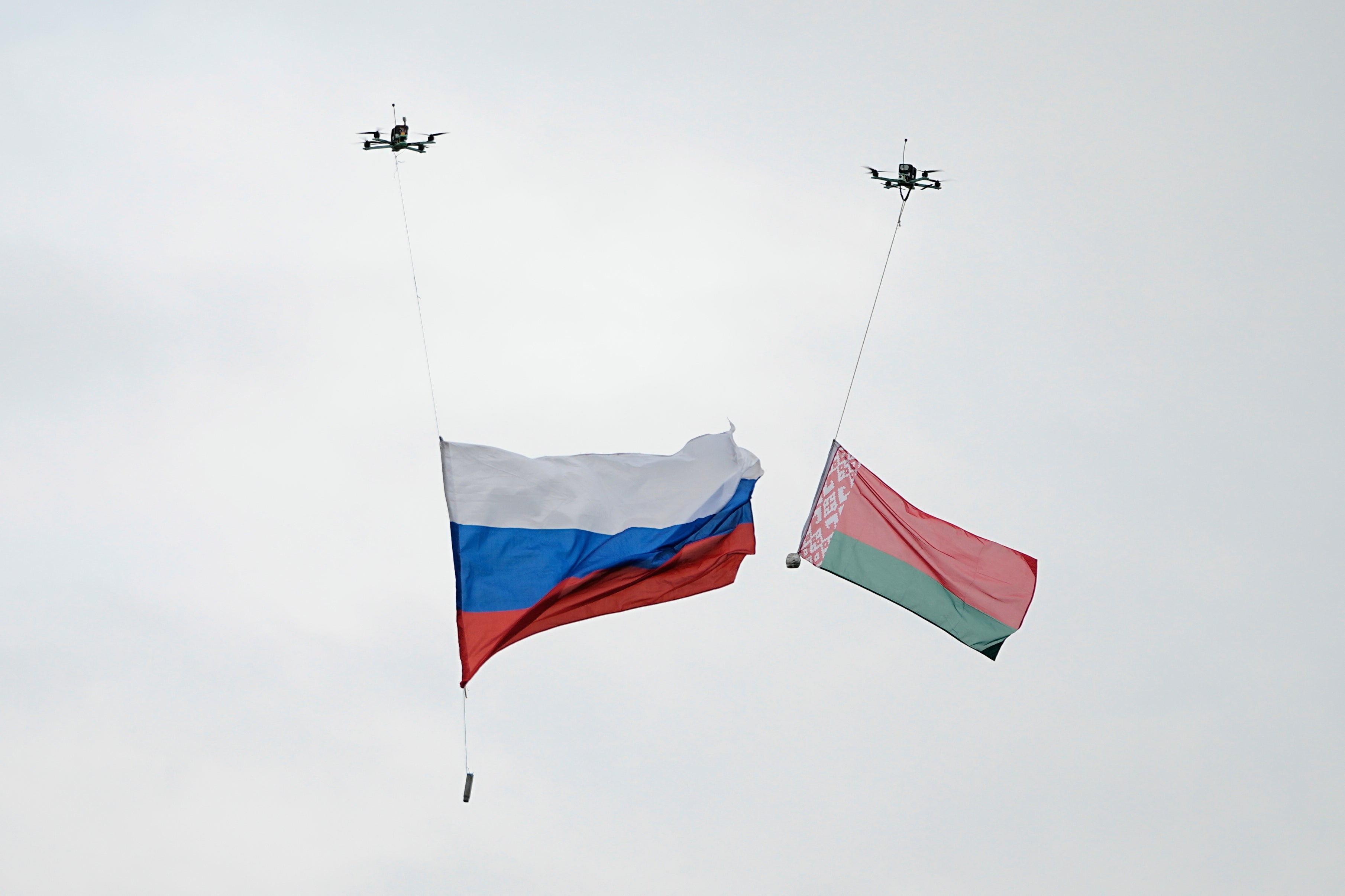 Drones each carry a Russia, left, and Belarus national flag, during the joint Russian-Belarusian military drills at a training ground near Barysaw, Belarus, Monday, Sept. 15, 2025. (AP Photo/Pavel Bednyakov)