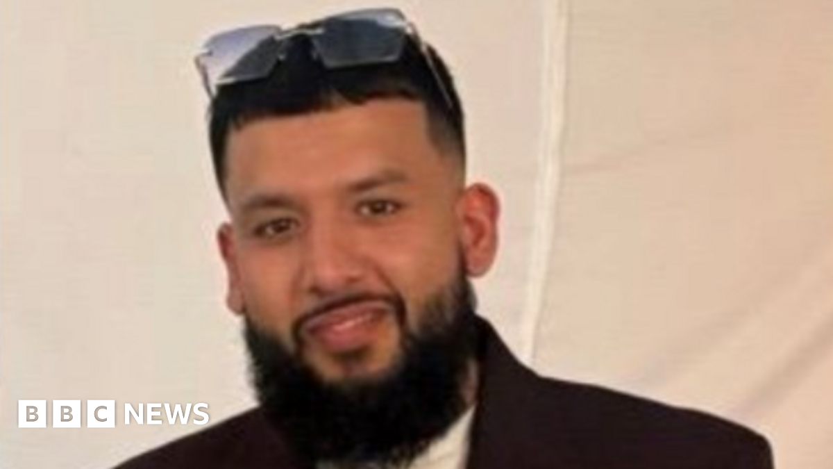 A resident walks with a shovel along a mud-covered road in Hualien on September 24, 2025, following the bursting of a barrier lake during the passing of Super Typhoon Ragasa.