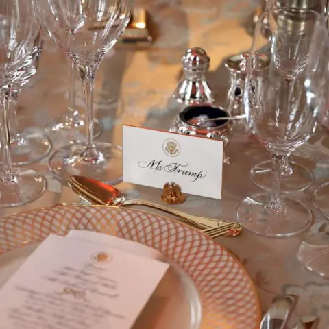 Chris Jackson - WPA Pool/Getty Images A dinner setting with gold cutlery and a place card that reads Mr Trump
