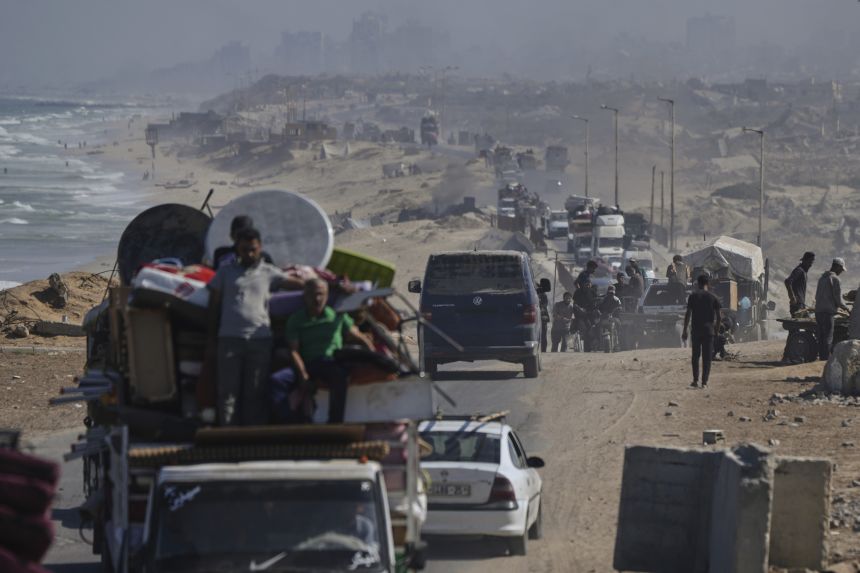 Displaced Palestinians fleeing northern Gaza carry their belongings along the coastal road toward southern Gaza after the Israeli army issued evacuation orders on September 9, 2025.