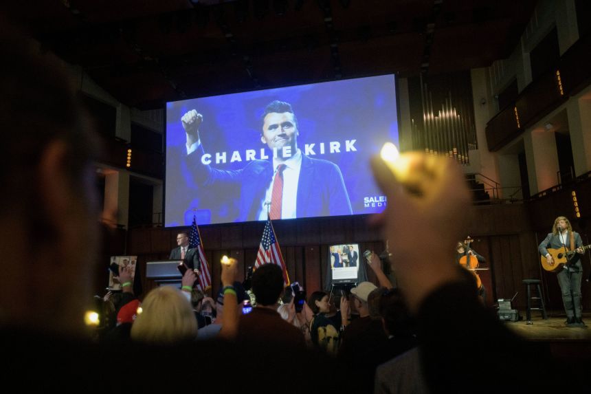 People hold candles and sing during a memorial and prayer vigil for Charlie Kirk at the Kennedy Center in Washington, DC, on Sunday.