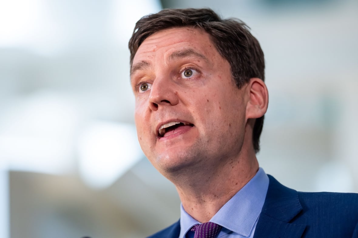 A white man wearing a suit speaks.