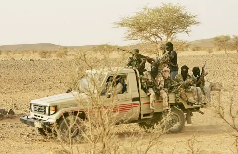 Getty Images Armed, masked men in a pick-up truck in northern Mali