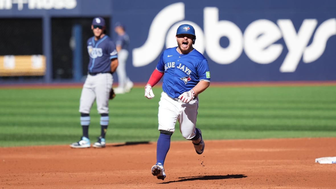 A baseball player reacts while rounding bases.