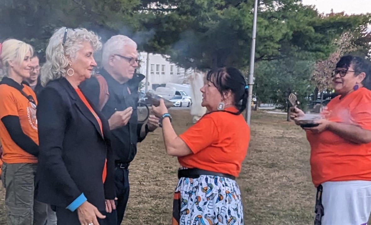 Two people are smudged with smoke during a traditional Indigenous ceremony.