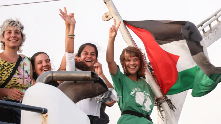 Greta Thunberg and a crew member flash victory signs from their ship, part of the Global Sumud Flotilla aiming to reach Gaza in Crete island, Greece on 25 September 2025 (Reuters)