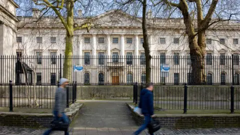 Betty Laura Zapata/Bloomberg via Getty Images Passers-by walk past the the Royal Mint Court office complex in the City of London the possible future site of a new Chinese Embassy 