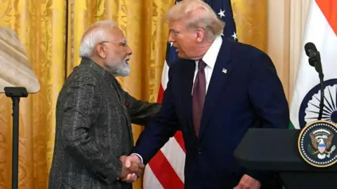 AFP via Getty Images Donald Trump shaking hands with Narendra Modi at a press event