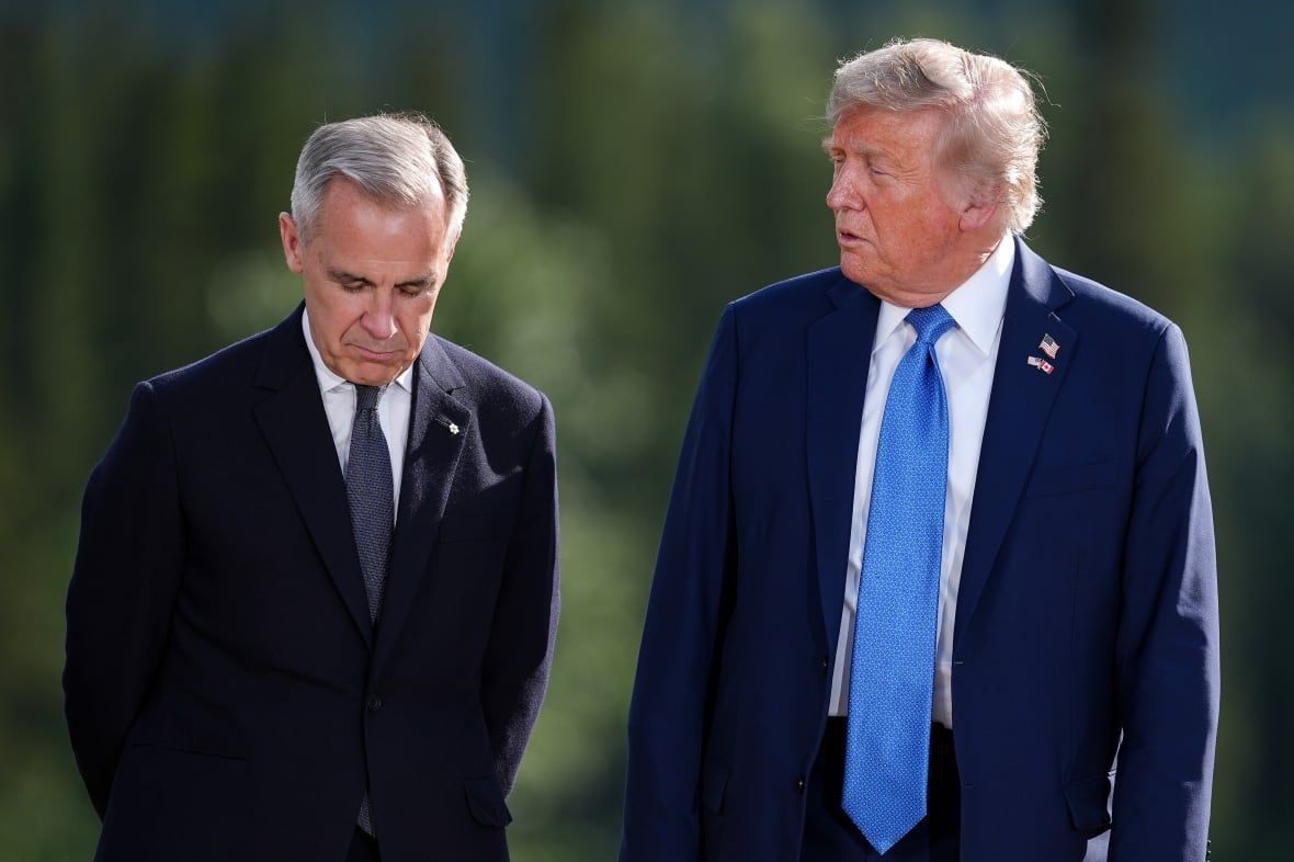 Prime Minister Mark Carney, left, listens to U.S. President Donald Trump while posing for the family photograph during the G7 Summit in Kananaskis, Alta., Monday, June 16, 2025.