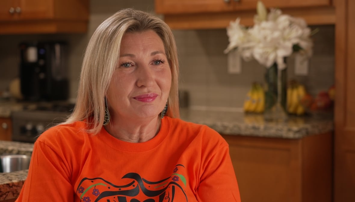 Close up photo of Charlene Simone wearing and orange shirt. 