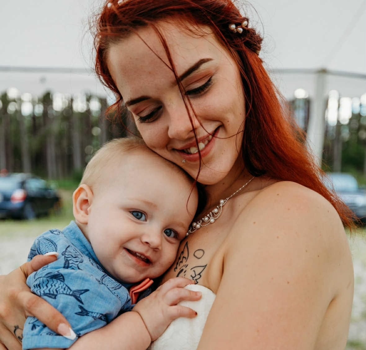 young woman with long hair holding baby in her arms